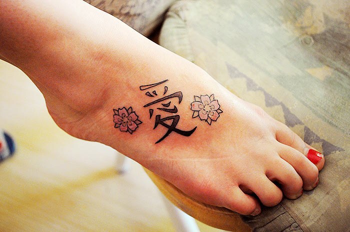 Superb Red And Black Color Ink Chinese Love Tattoo On Foot For Girls
